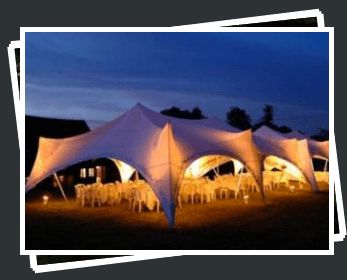 Evening marquee setup with round tables and warm lighting