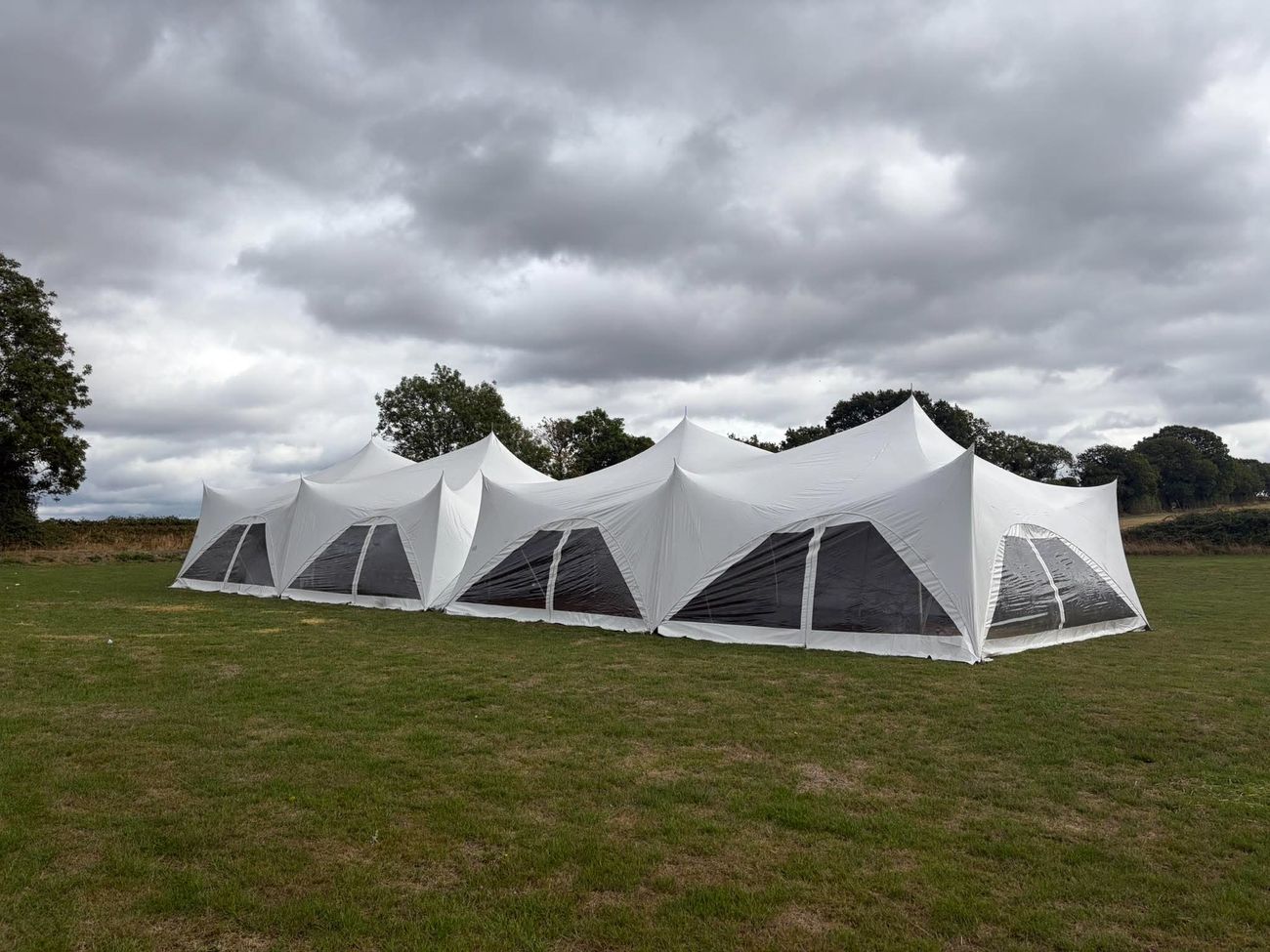 Linked Capri marquees with clear window walls in an open field