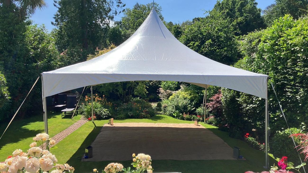 White pagoda marquee with no side walls in a summer garden